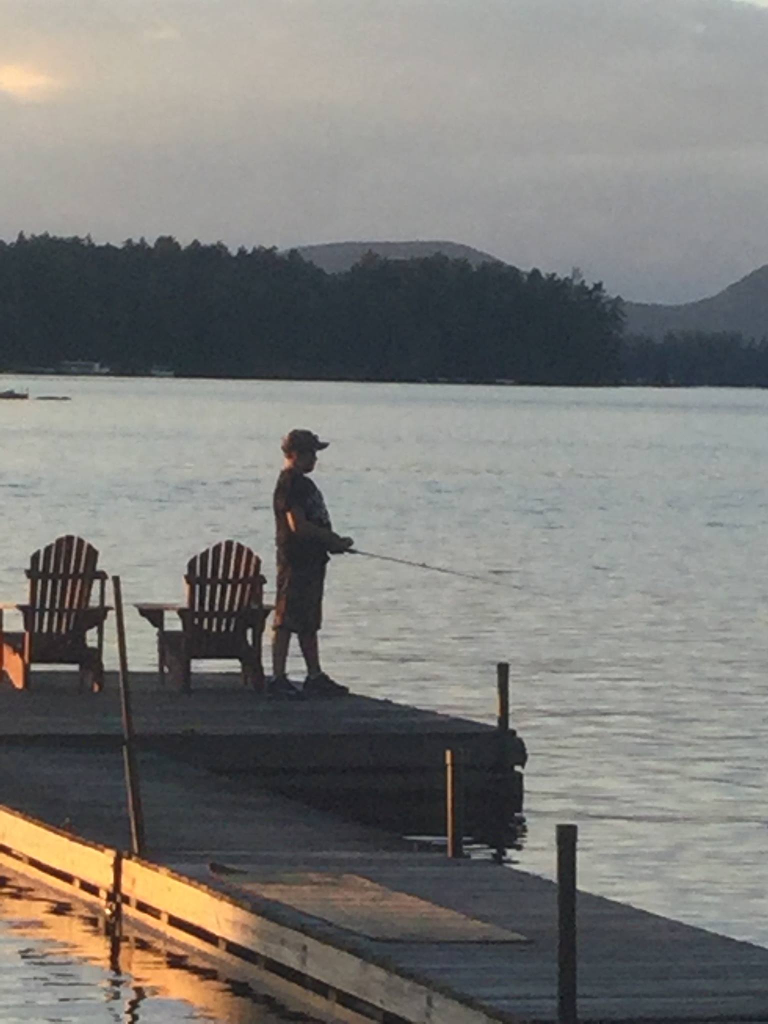 Photo of child fishing and standing on a dock